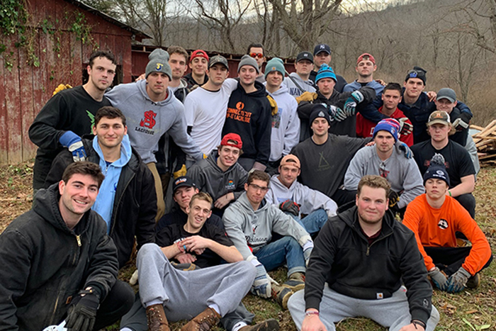 The Dickinson College men's lacrosse team takes a moment from their work to take a group picture during a service trip to West Virginia.