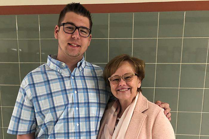 Photo of Jacob Bream standing with Margee Ensign in front of a green-tiled wall.