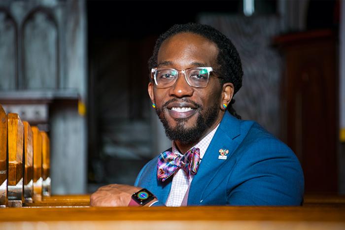 Portrait of Jay Williams sitting in a church pew.