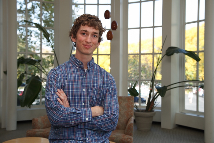 Alex Kasznel poses in the library.