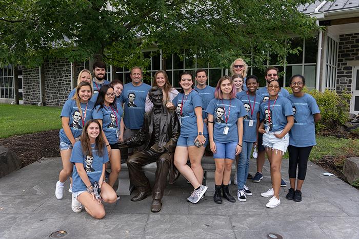 Members of the Knowledge for Freedom program pose with a statue of Abraham Lincoln.