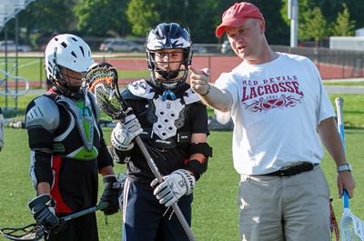 Picture of Coach Webster with student lacrosse players