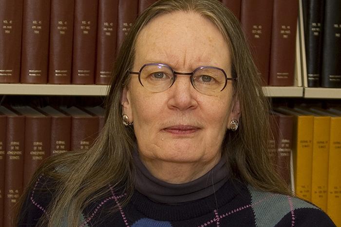 Photo of a woman in front of a bookshelf.