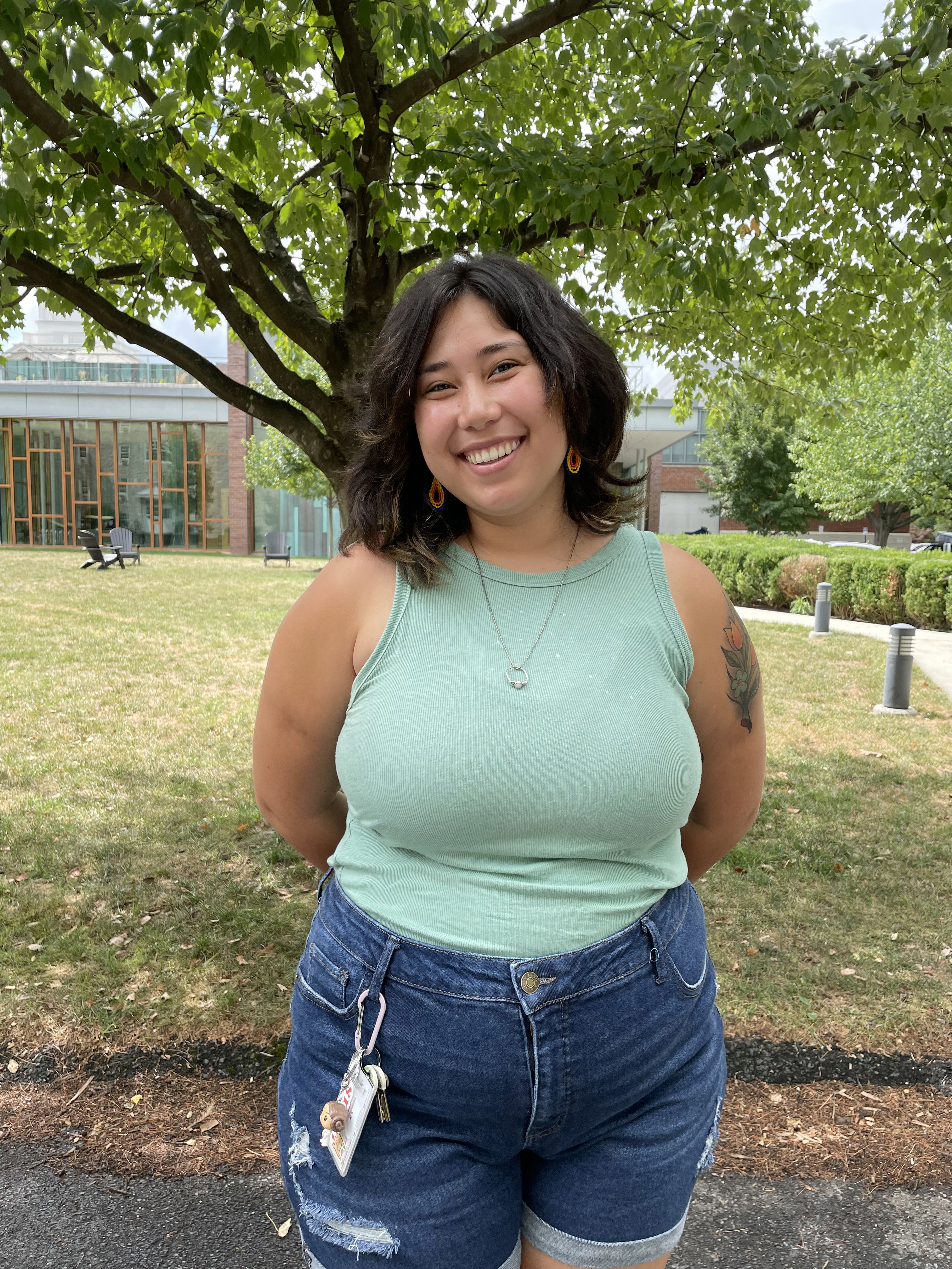 A person wearing with dark hair wearing a green shirt