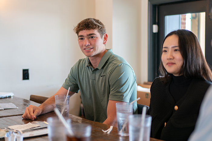 Shane Mundorf '25 (left) and Ashley Kim '24 will begin their internships this summer. Above, they meet with the couple at a local eatery, prior to their trip. Photo by Dan Loh.