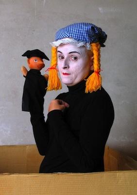 Performer Bridge Markland in costume holding a puppet.