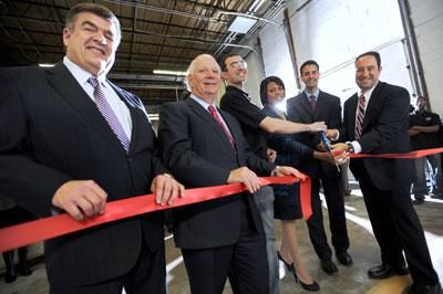 Drew Greenblatt '88 (far right) does the honors at a Jan. 12 ribbon-cutting ceremony commemorating his company's latest acquisition.