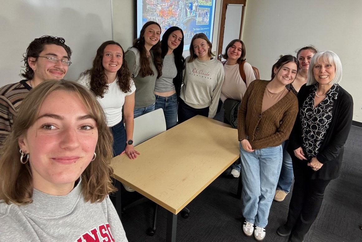 Selfie-style photo of ten people inside a classroom.