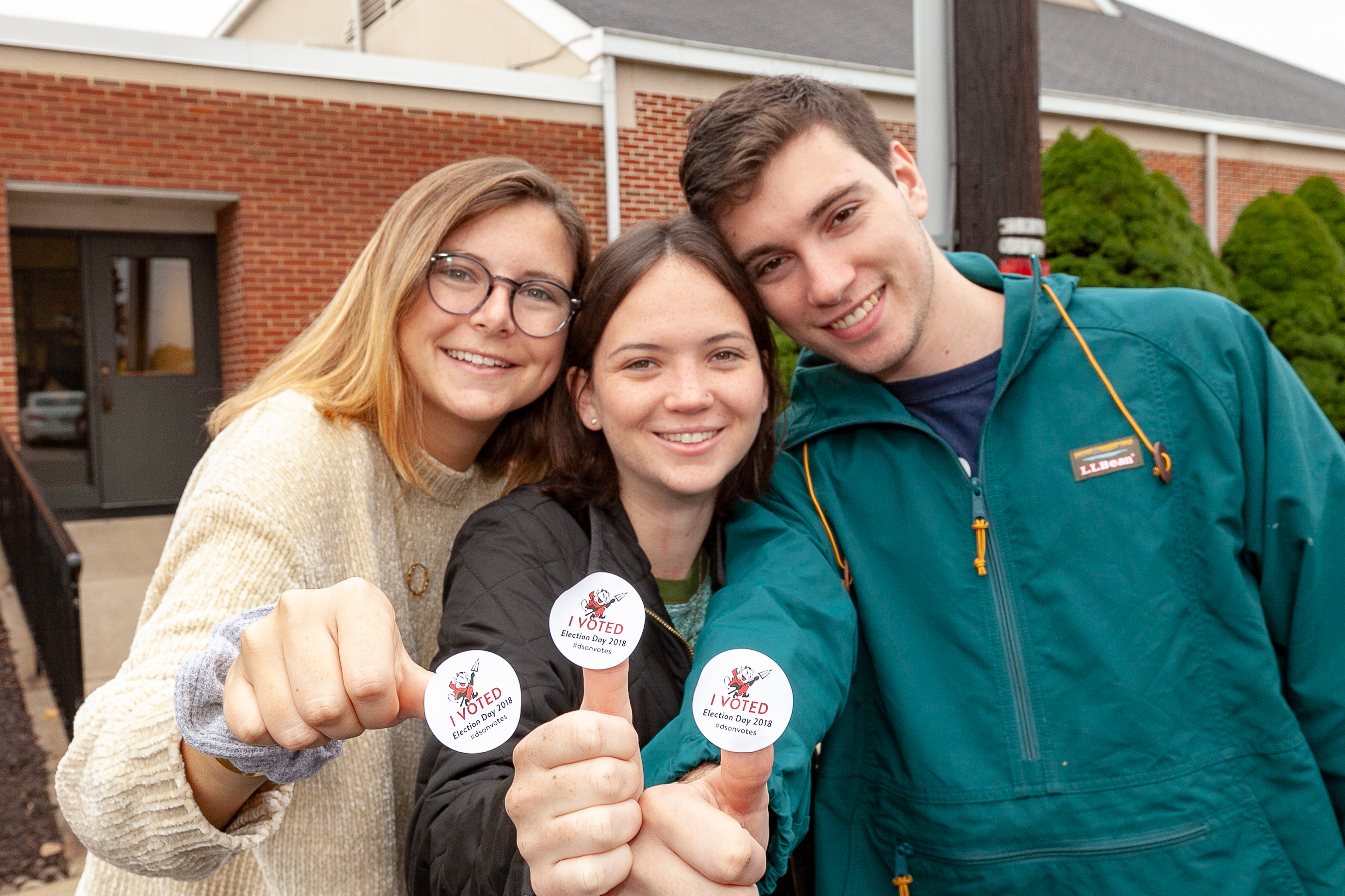 Three students displaying their I Voted stickers.