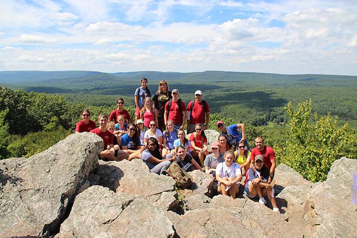 A Sustainable Local Adventure Pre-Orientation group posed for a photo at the top of Pole Steeple.