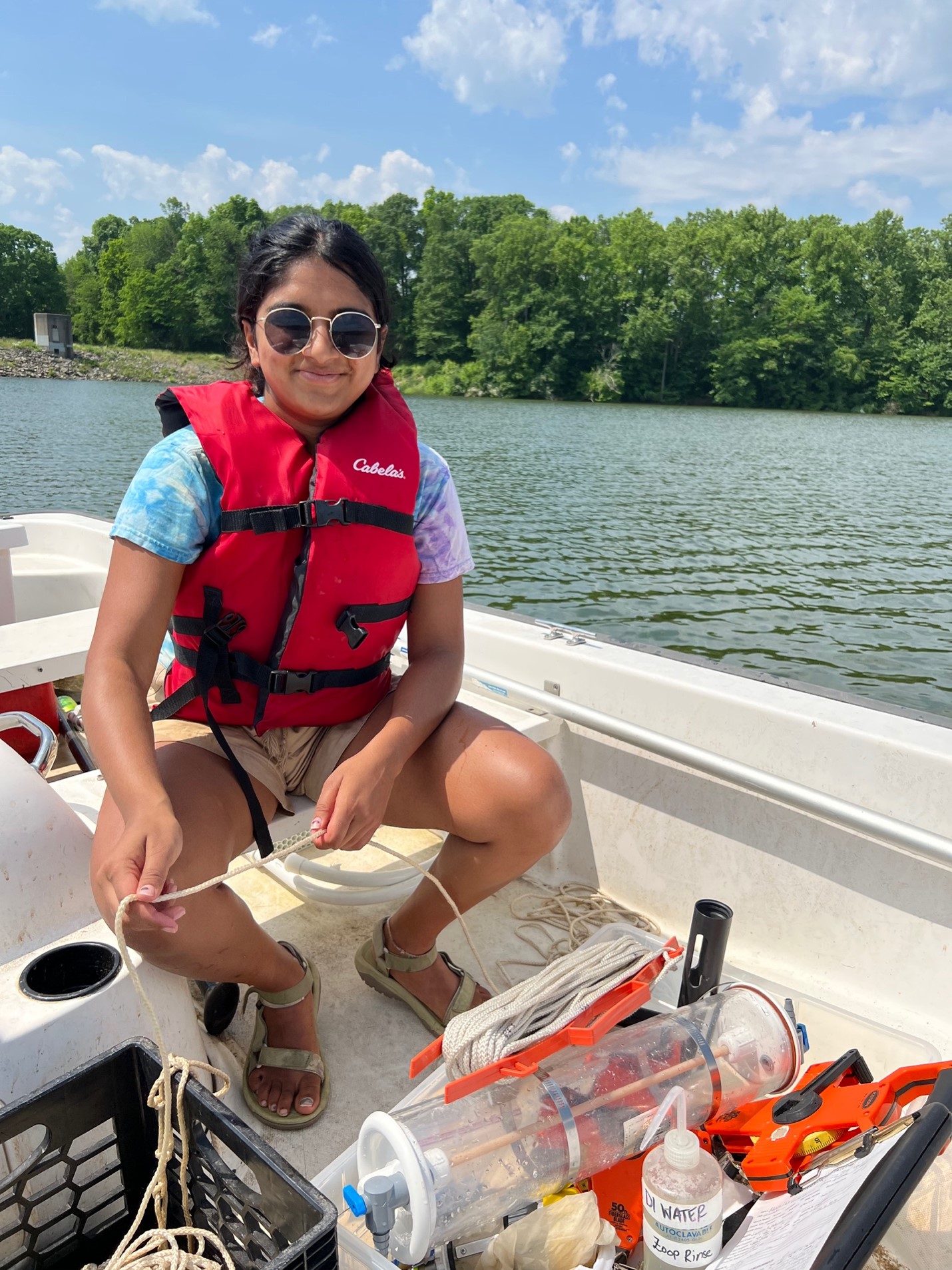 Prerana sitting on a research boat floating in the water 