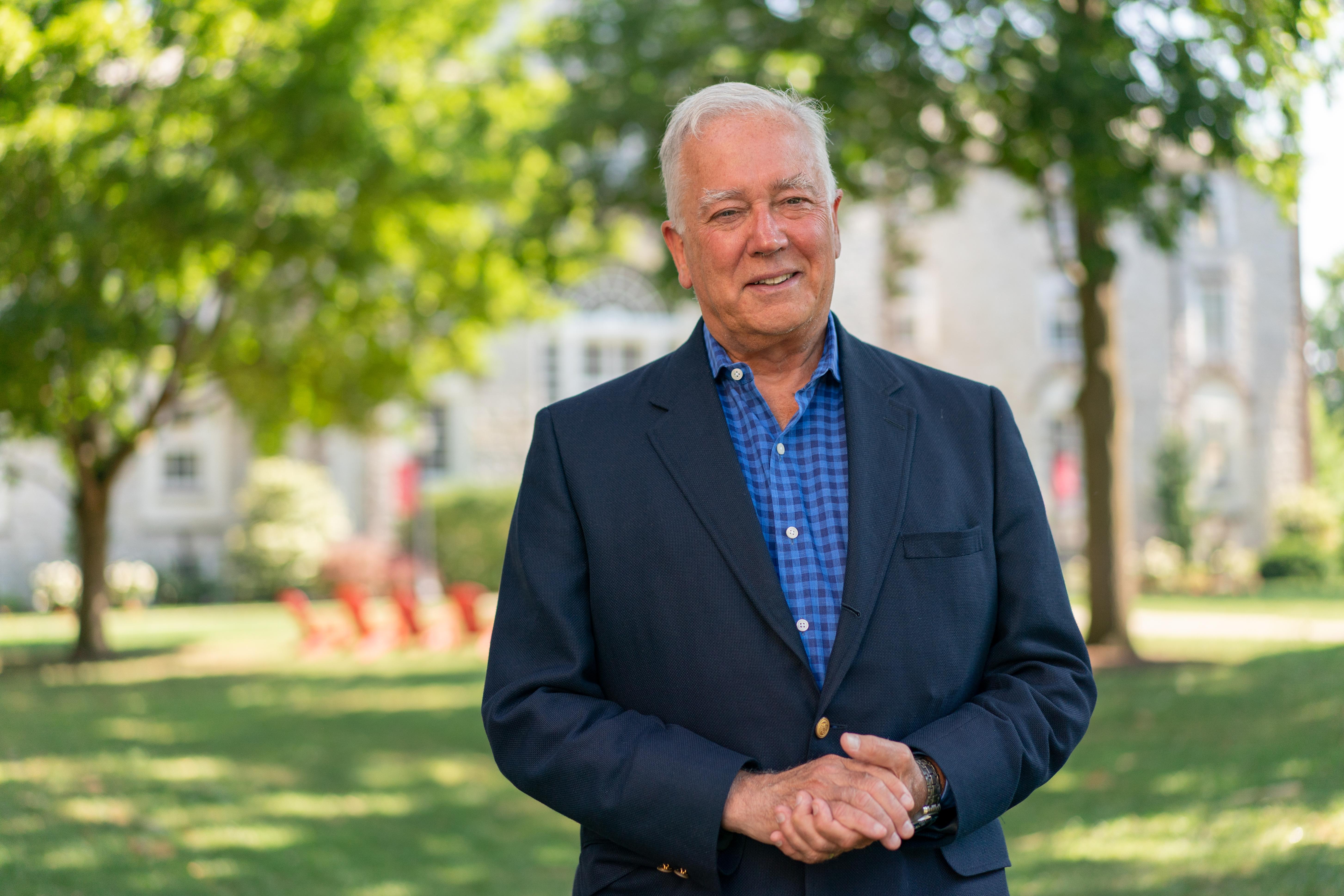 Portrait of Dickinson College President John E. Jones III standing among the trees on the Academic Quad.