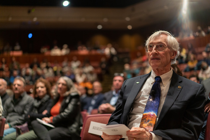 John Mather sits in a full auditorium