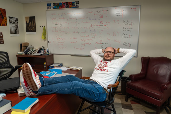 scott farrington reclines in a chair in his office