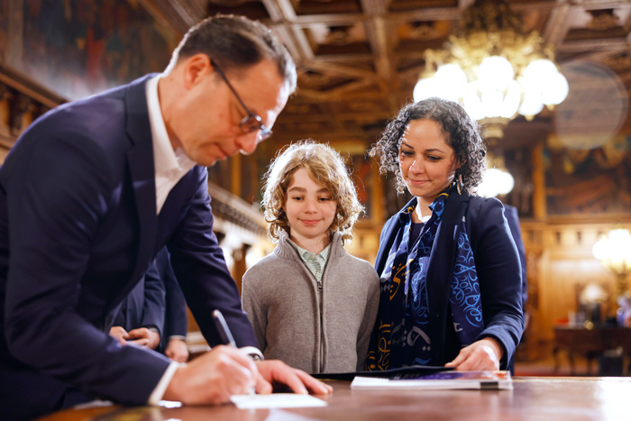 Mireille Rebeiz and her son watch Gov. Josh Shapiro sign the declaration