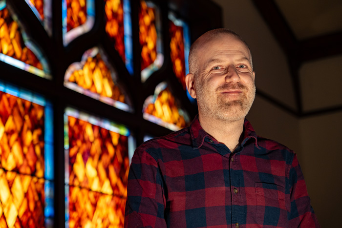 Toby Reiner in front of stained glass