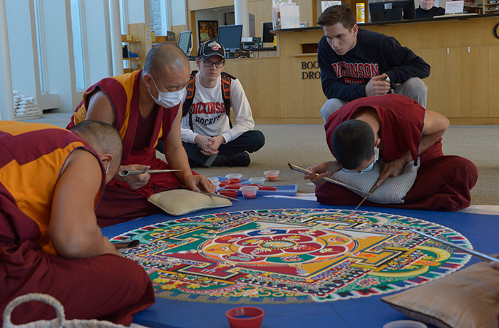 Students watching the building of a mandala in the Dickinson Library.