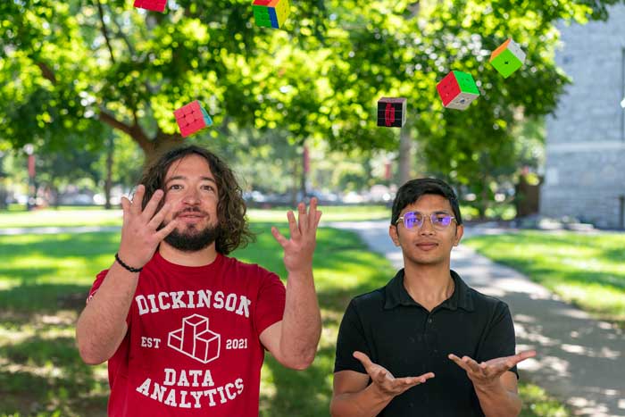 a professor and a student toss rubik's cubes into the air