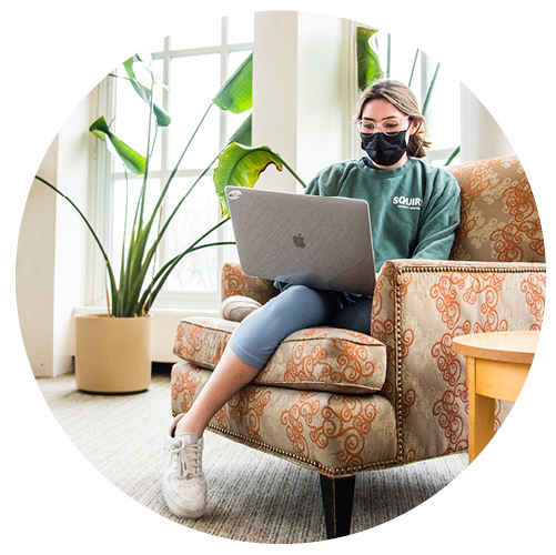 masked girl working on her laptop