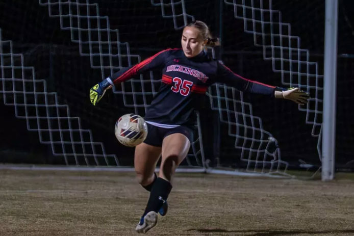 A goalie punts the ball away from the goal
