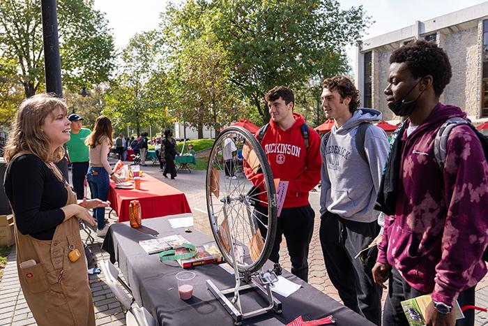 Students standing around a bicycle wheel.