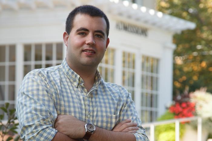 David Tretter poses in front of the admissions building.