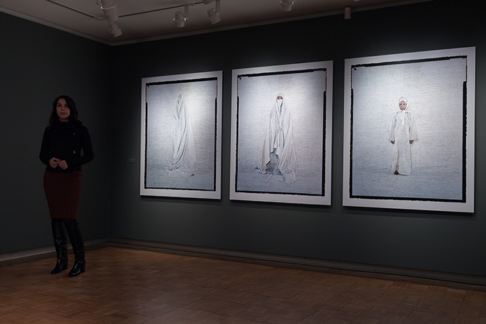 Artist Lalla Essaydi poses in front of her work, hung in The Trout Gallery. Photo by Carl Socolow '77.