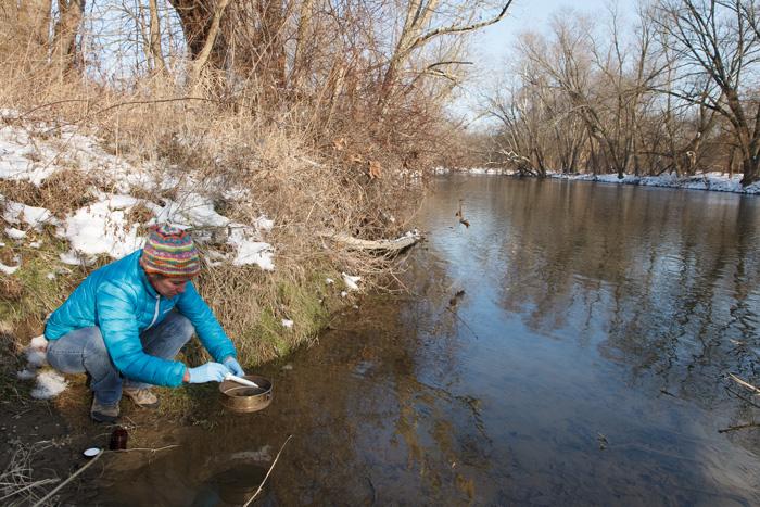 Associate Professor of Chemistry Amy Witter collects surface sediments along the Conodoguinet Creek. Urban collection sites showed strong correlations with coal-tar-based sealcoat runoff.