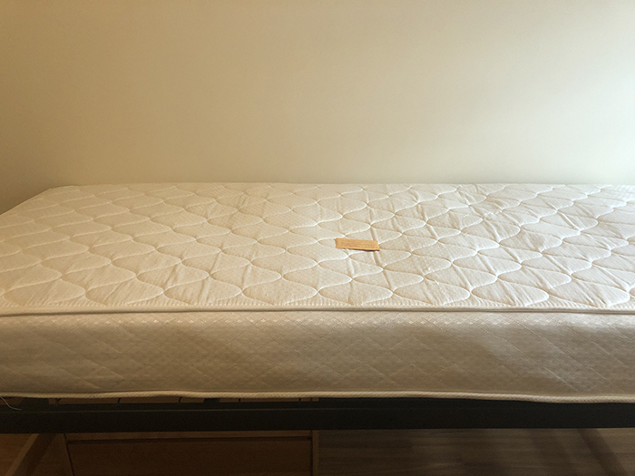 A bare mattress and a residence hall room key, after a midsemester move-out. Photo by Elizabeth Krause '20.