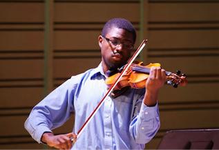 Photo of the Dickinson College music and violin performance student Alexander Strachan, seen here performing with his instrument.