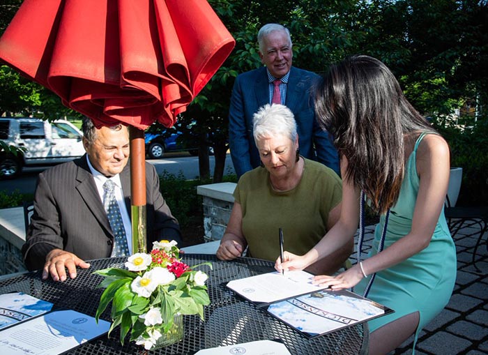 Lainey Herndon '22 signs the gift agreement for the new program as her grandparents and President John E. Jones III '77, P'11, look on. The Alleys dedicated the new health-studies service-trip program to Lainey, who inspired it. Photo by Caroline O'Conner.