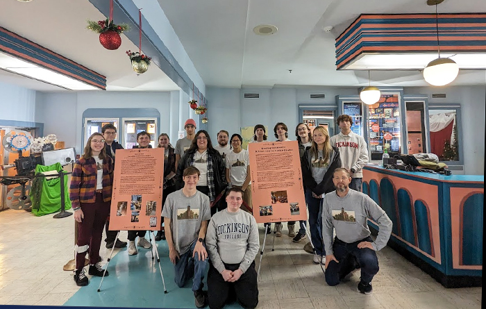 Students in a class taught by Professor of History Karl Qualls (first row, far right) pose in front of two of their displays on Carlisle Theatre's history. Photo courtesy of Qualls.