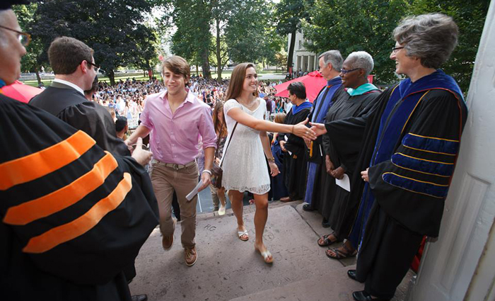 Neil Weissman (foreground, left), provost and dean, and President Nancy Roseman (foreground, right) welcome the first two members of the class of 2017 to ascend the steps of Old West. They will descend those steps in four years when they graduate.