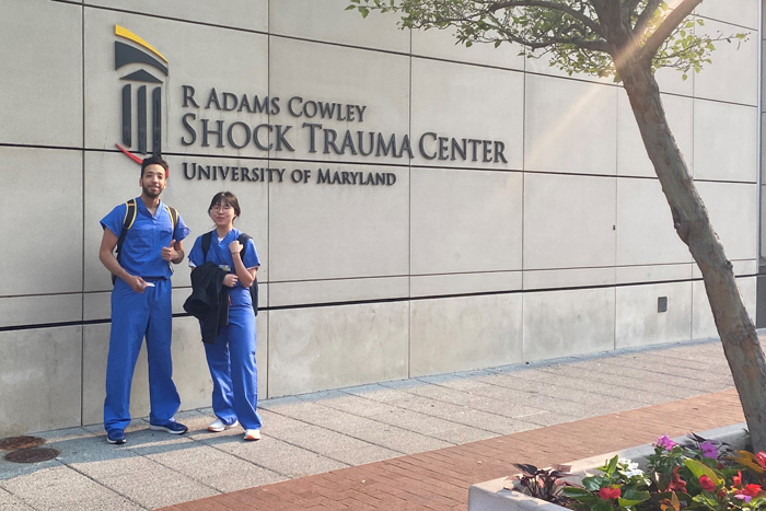 two student stand in front of the medical center