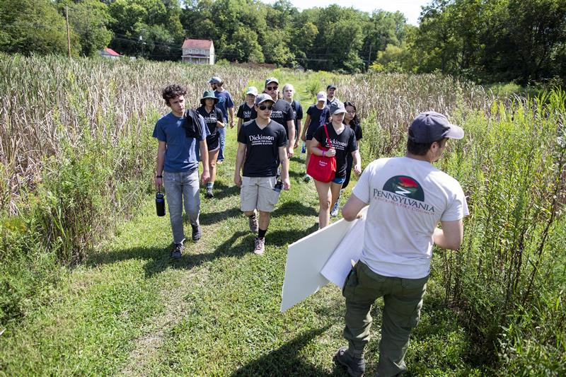 A group of Center for Civic Learning & Action students walking outside with a representative from the Central PA Conservancy.