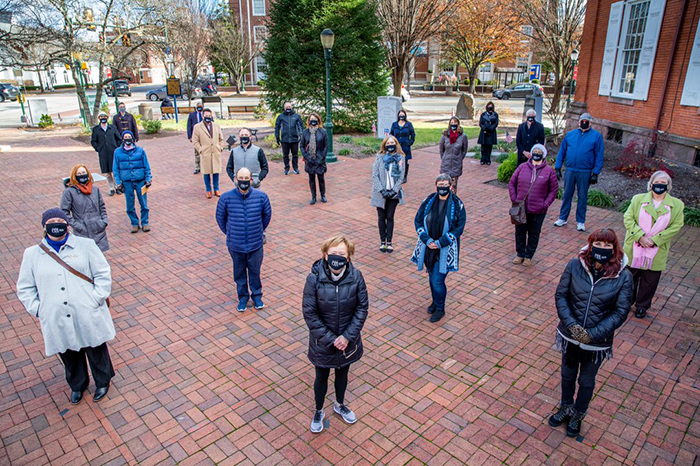 Members of Carlisle's Community Action Network pose in the town square. "If we all do our part, we'll be able to stem the spread," said President Margee Ensign (front row, second from left).