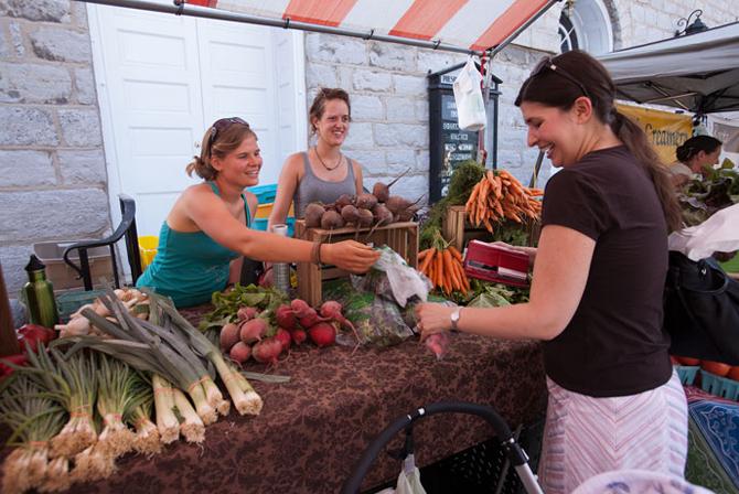 Students selling vegetables at the local farmer's market