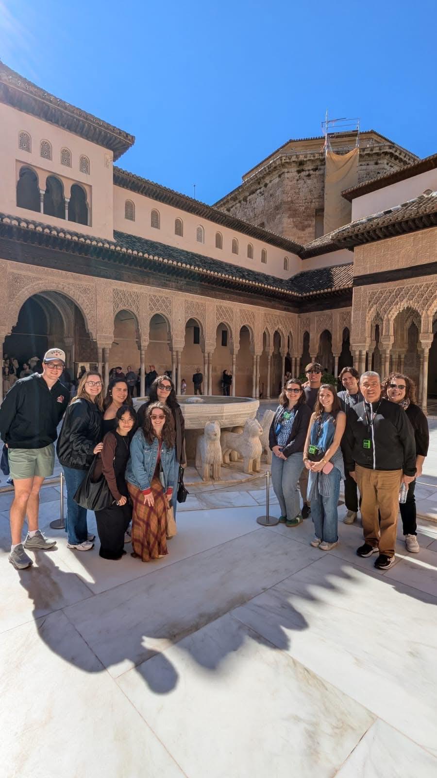 Malaga Program Director Erin Diaz poses with students outside a Spanish building