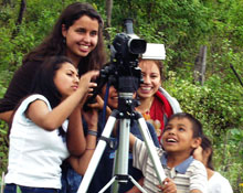 A Dickinson student helps some children with a video camera.