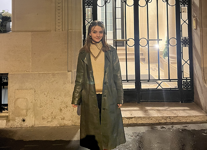 a young woman stands in front of an entranceway