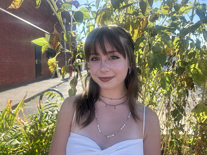 YOung woman in a white dress, by a tree