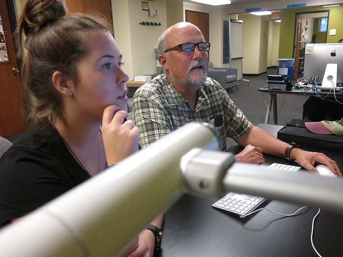 Kerin Maguire '17 and Ashton Nichols comb through the new web portal they created as part of a student-faculty research project. Photo by Tony Moore.