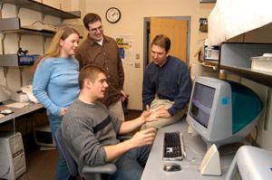 Photograph of students by a computer