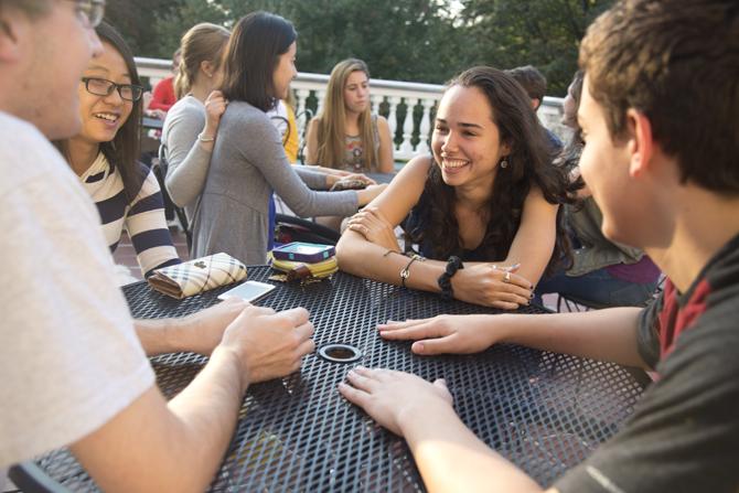 Students sitting on a residence hall deck. 
