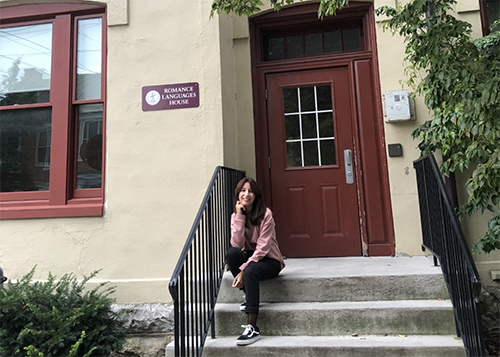 Spanish Student sitting outside of the entracne to Dickinson's Romance Language House