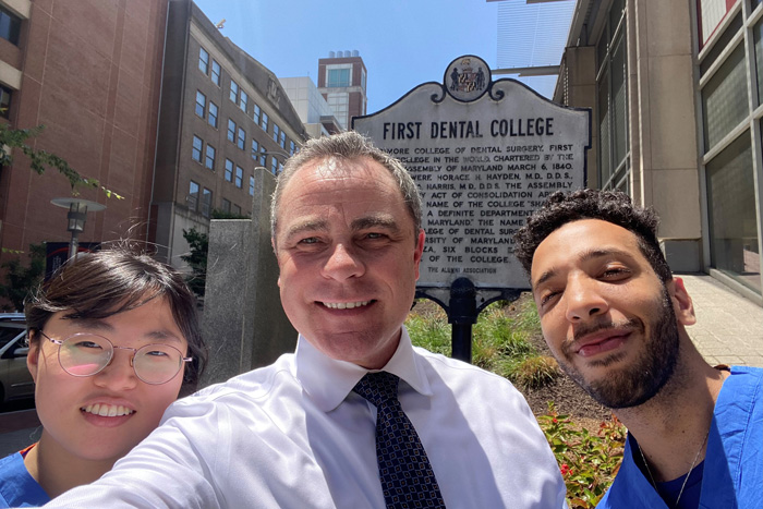 Two students and their professor pose for a selfie
