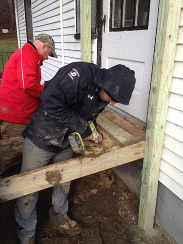 a student on the lacrosse team joins Head Coach Dave Webster on a building project in West Virginia.